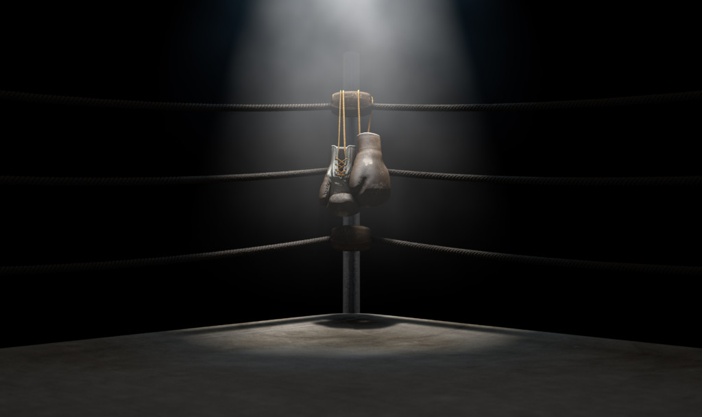 A vintage boxing ring with boxing gloves hanging from the corner.